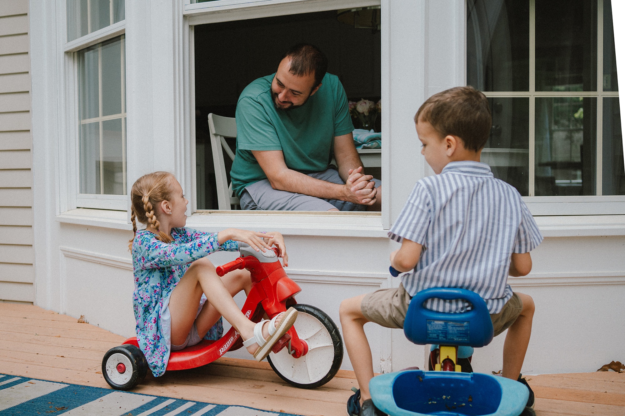 kids play outside kitchen window with dad