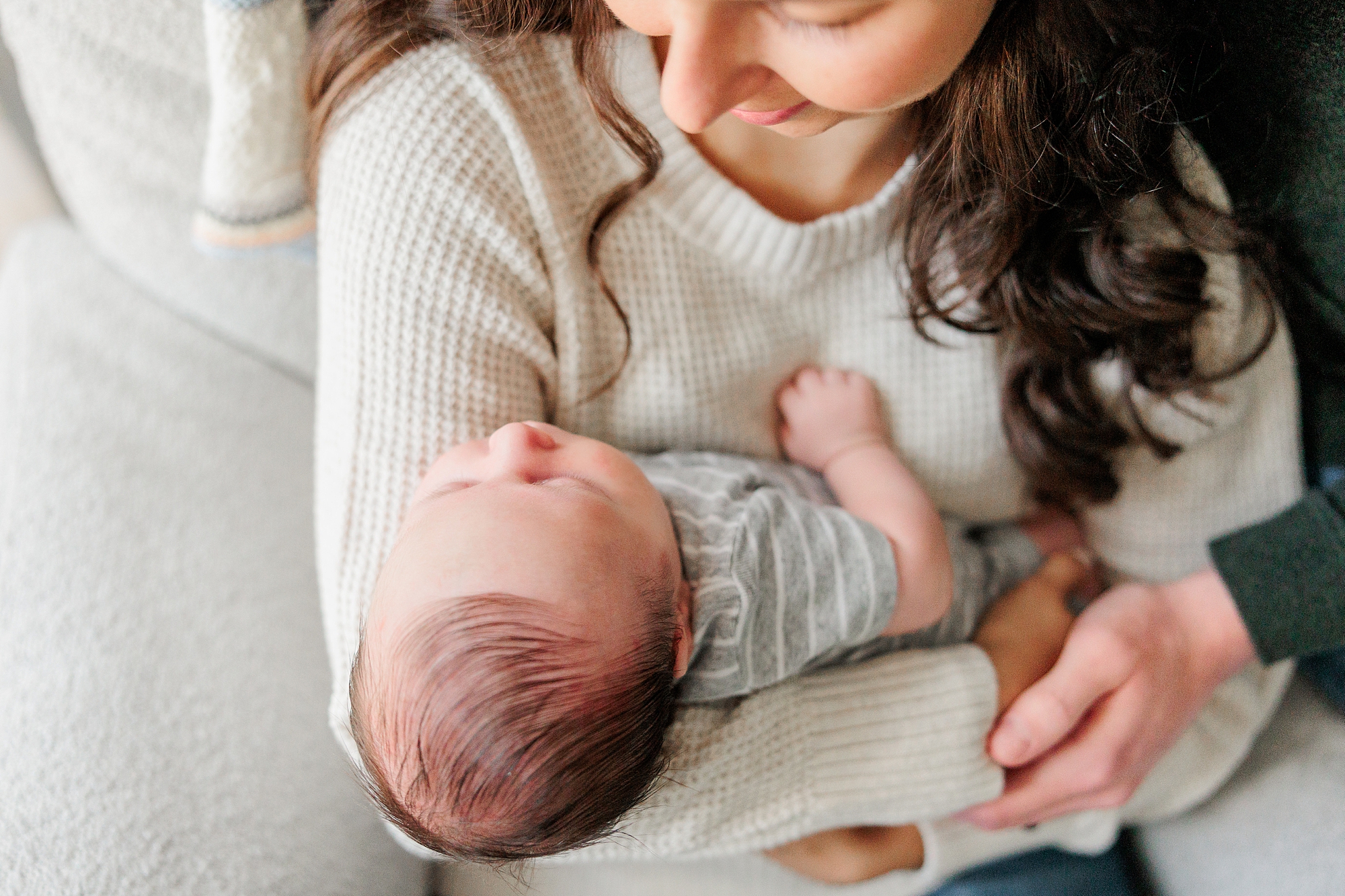 woman holds newborn son during lifestyle photos in Baltimore home