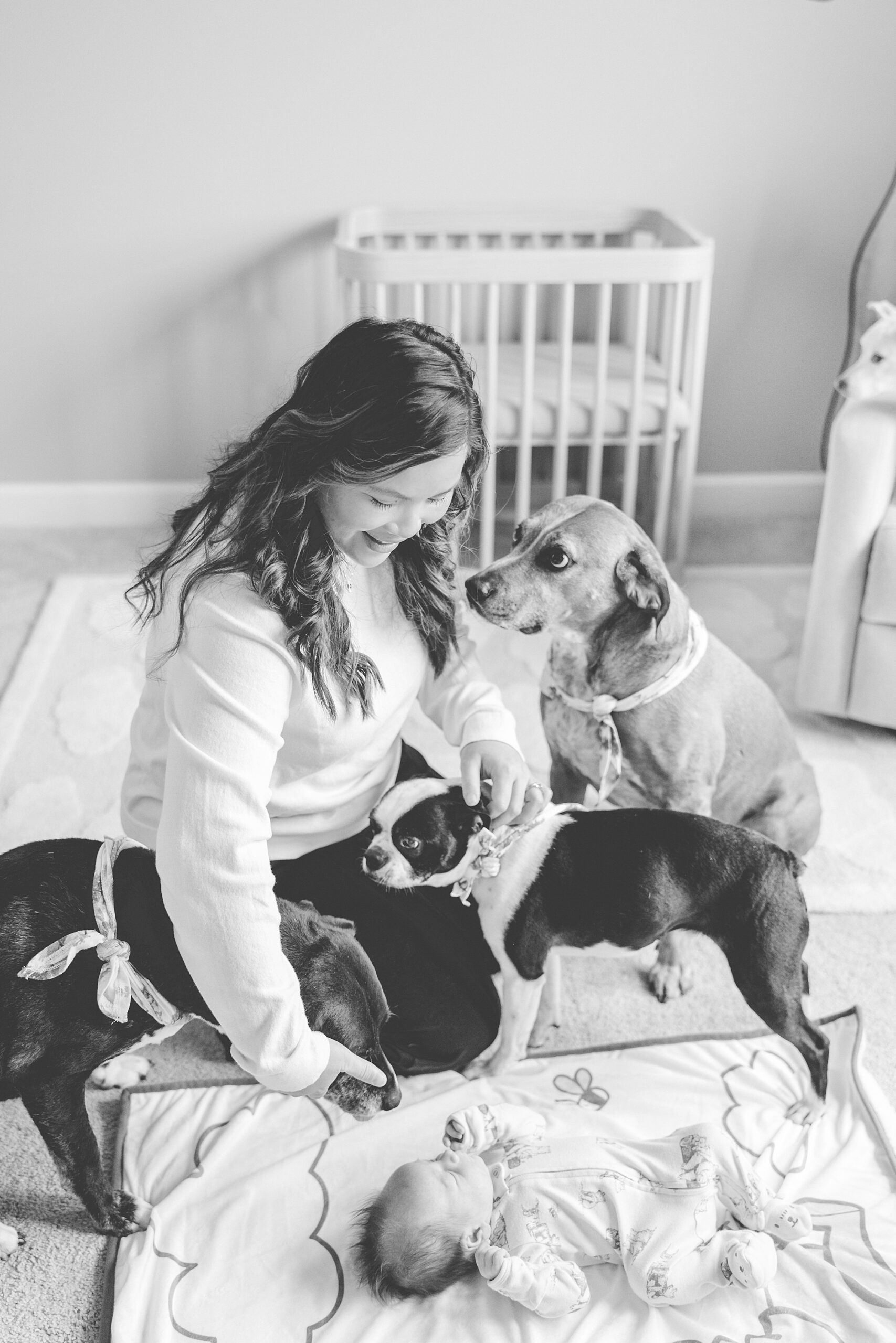 mom pets dogs on nursery floor during photos in Baltimore home