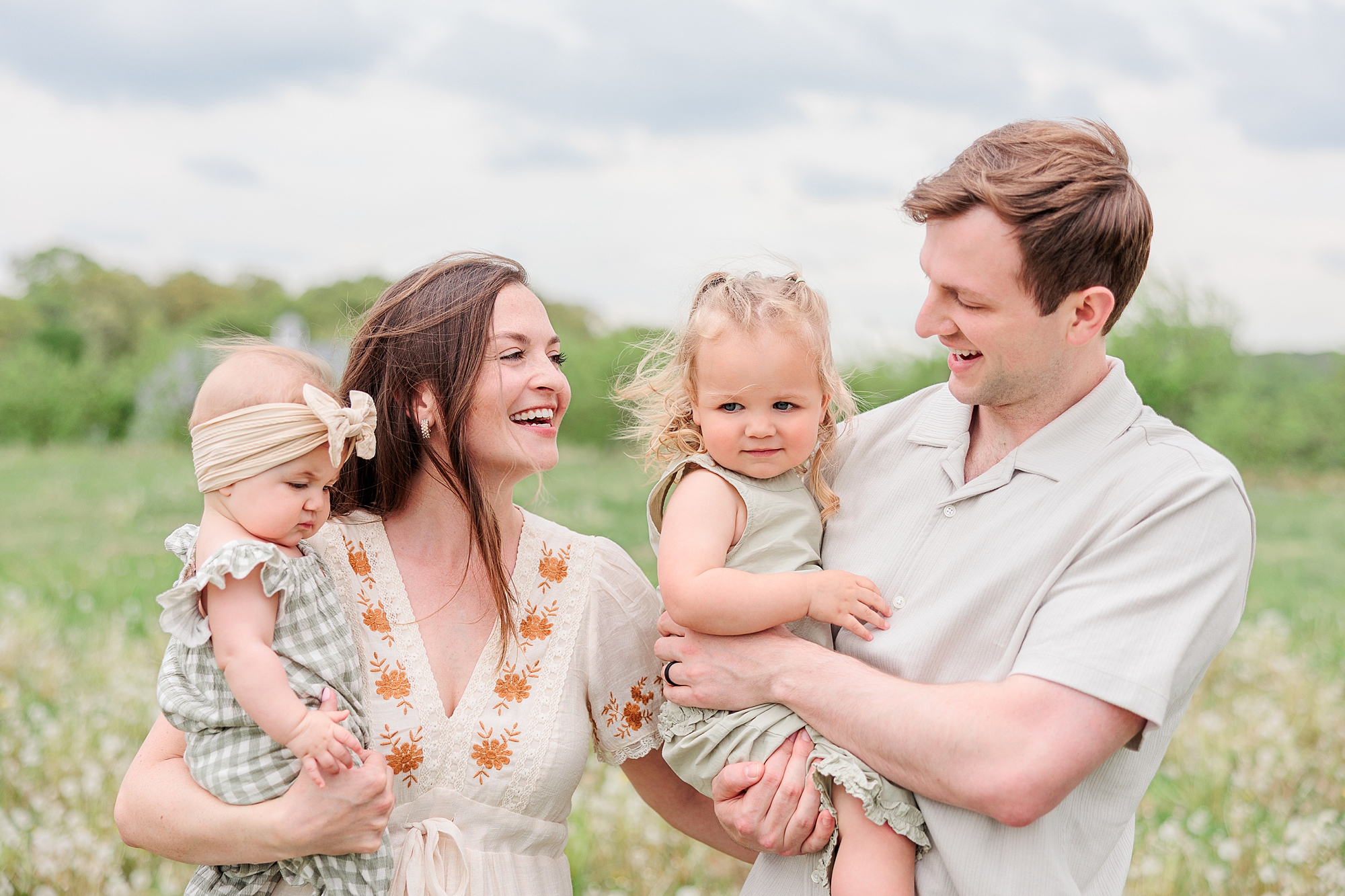 family of four hugs together during Baltimore lifestyle family session on farm