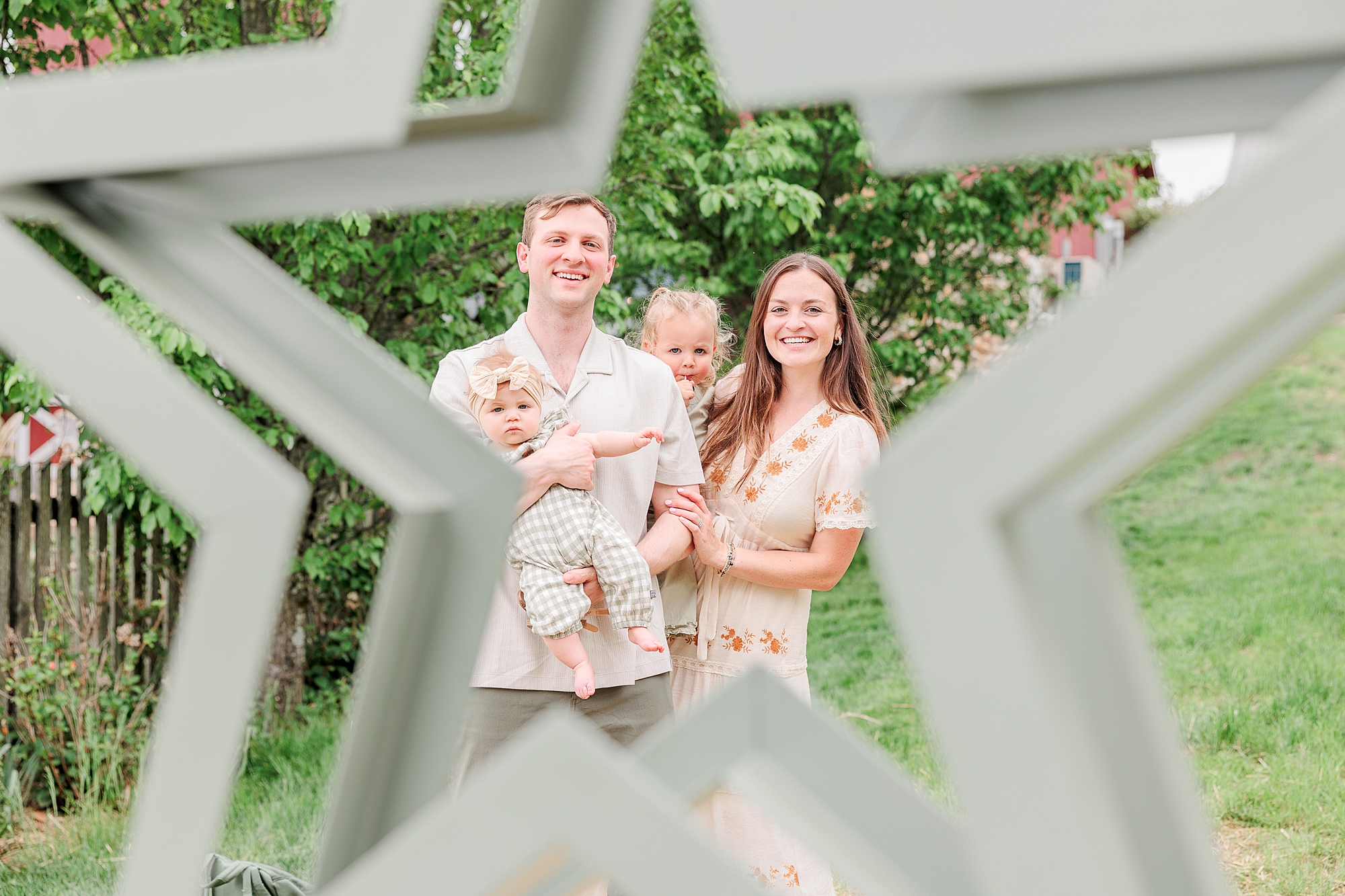 photo of couple holding baby girls photographed between star