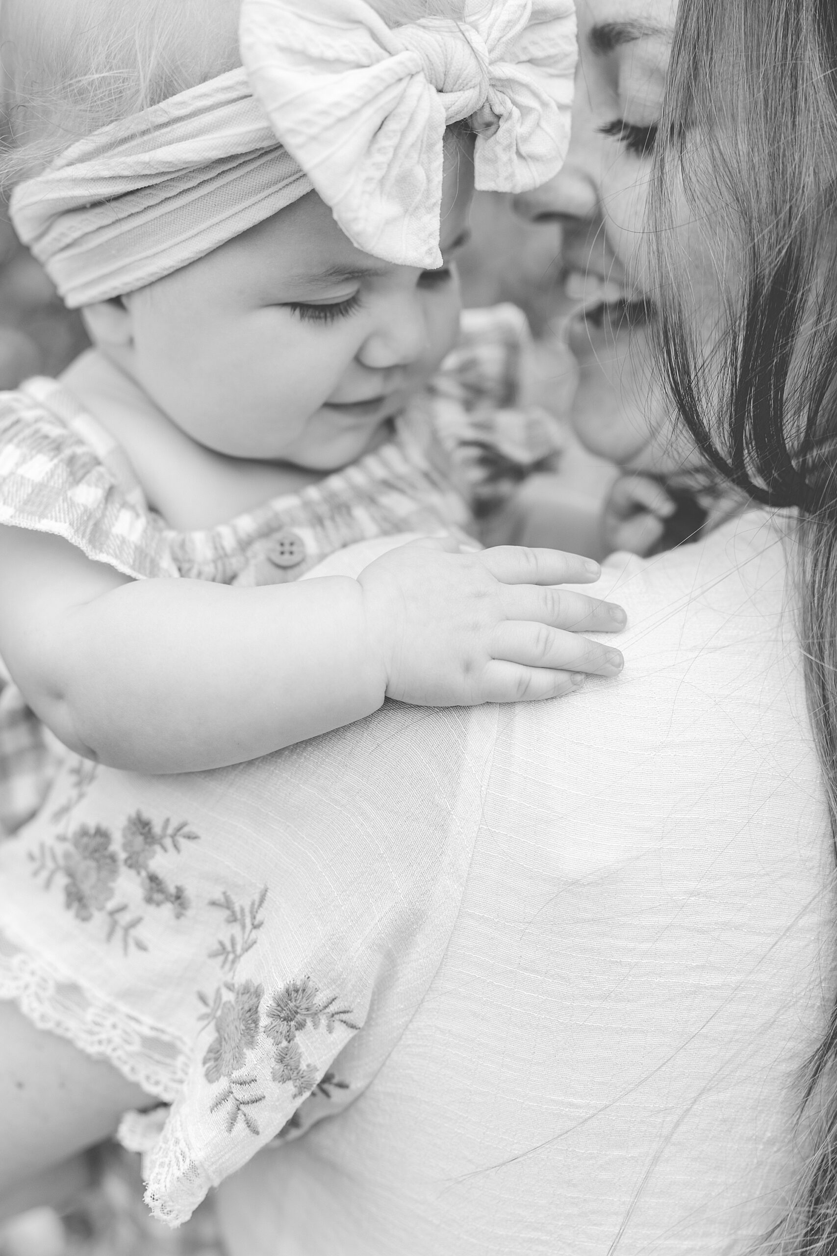 mom holds baby on her shoulder during Baltimore lifestyle family session on farm