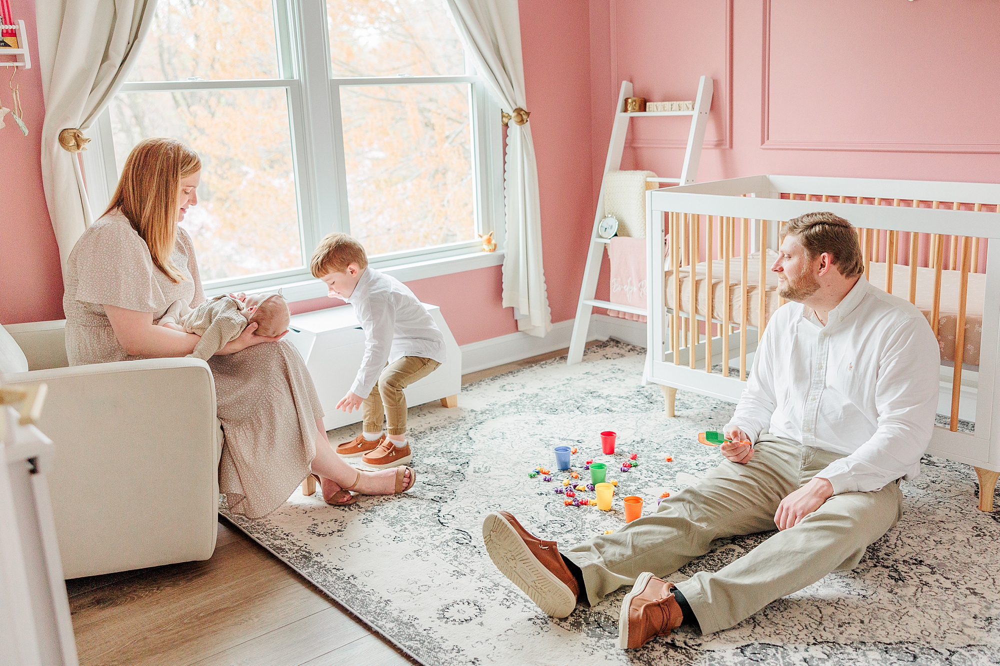 family sits and plays in nursery during Baltimore lifestyle newborn session