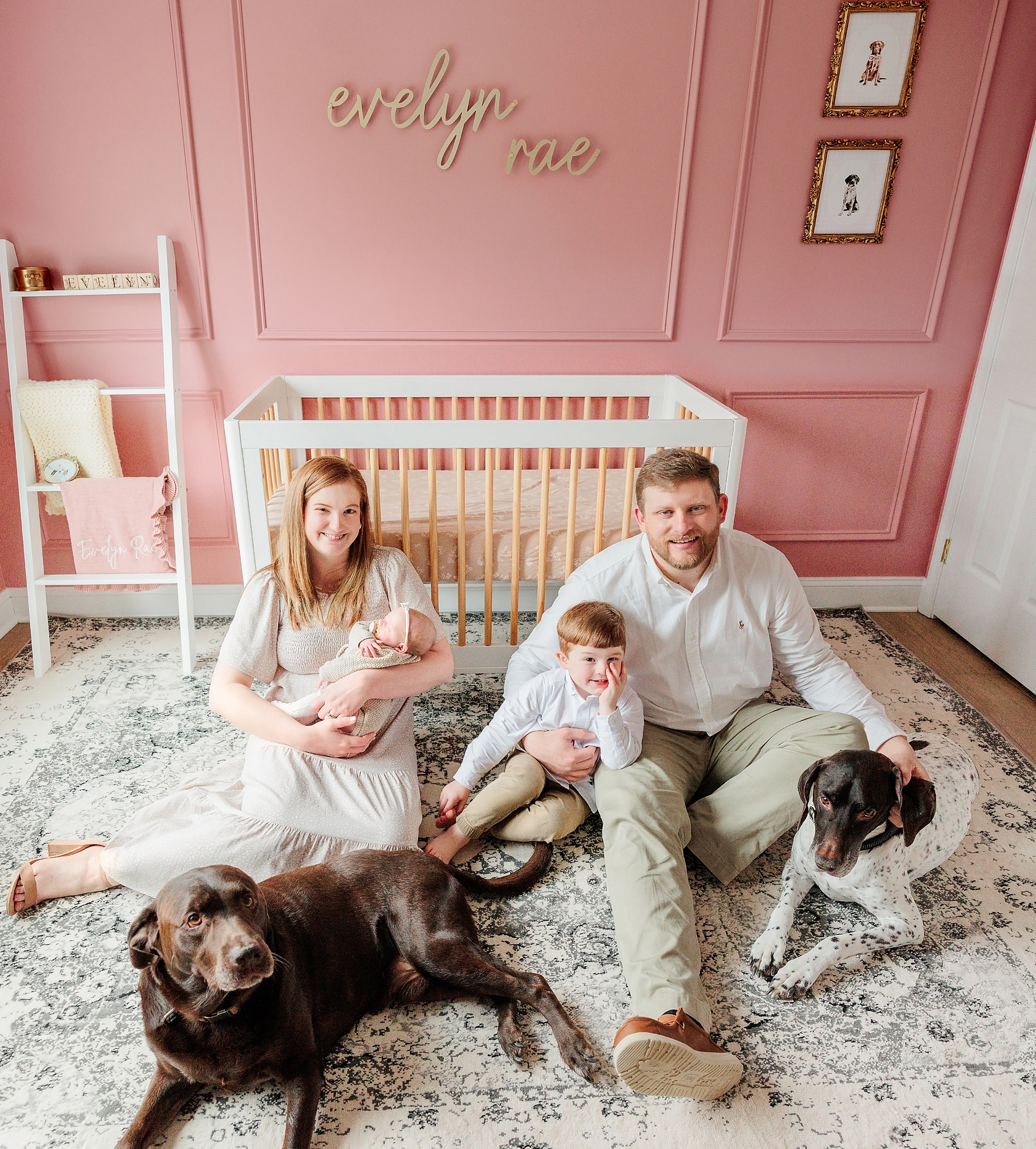 family sits with puppies and children during Baltimore lifestyle newborn session