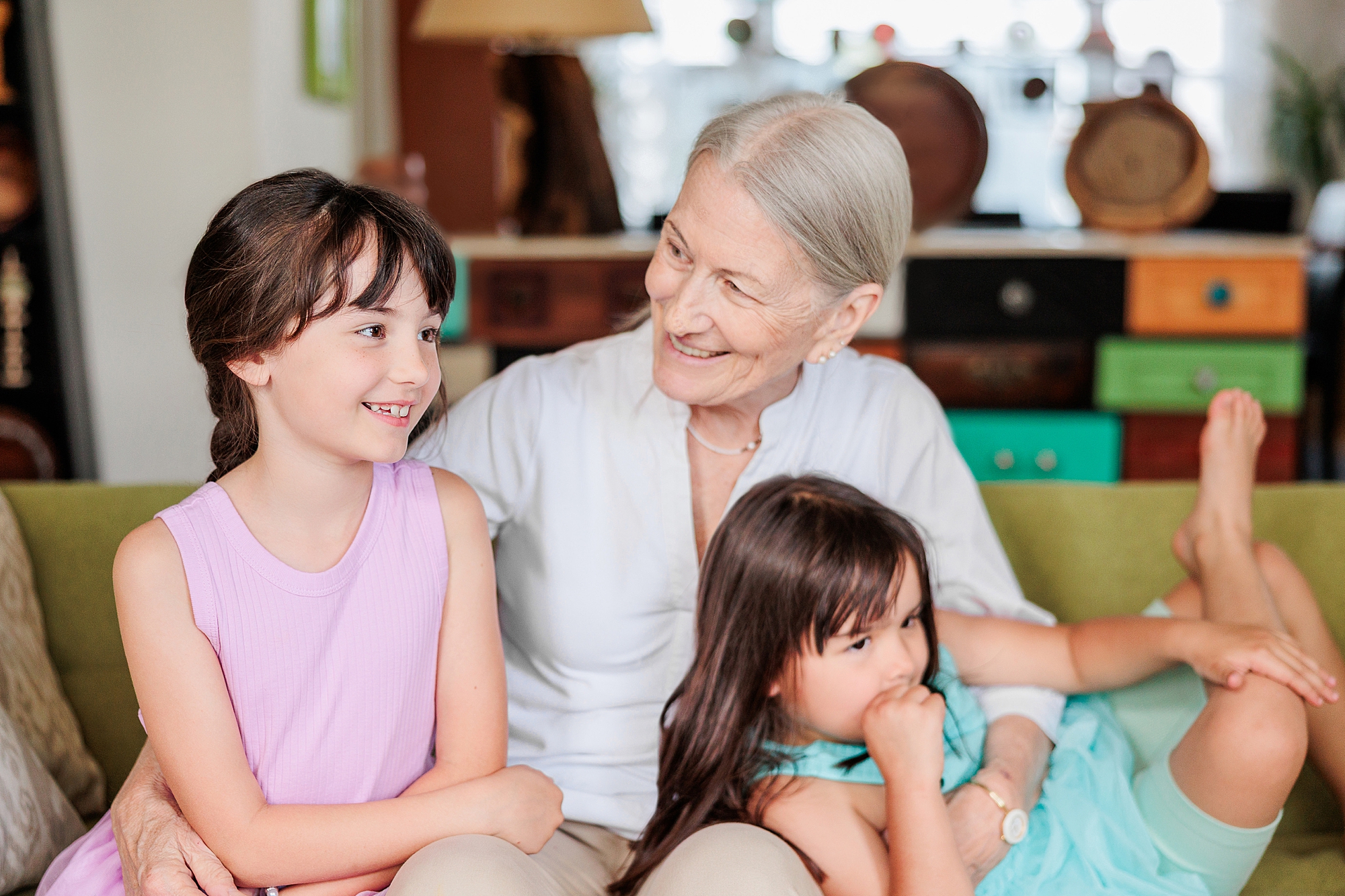grandmother sits with two granddaughters during extended family session with Annapolis Maryland family photographer