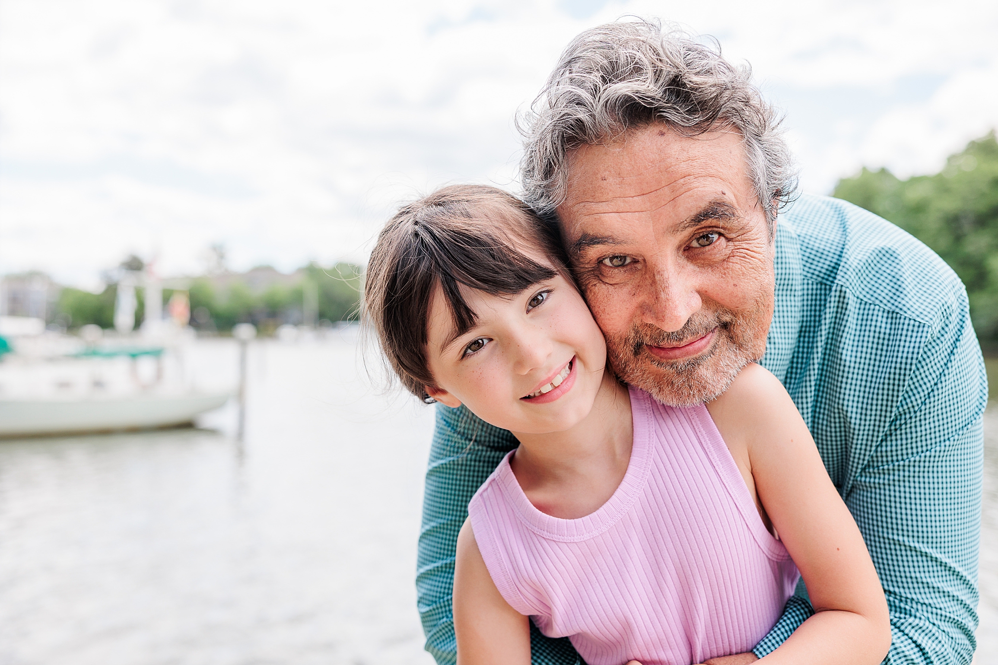 grandfather hugs granddaughter from behind 