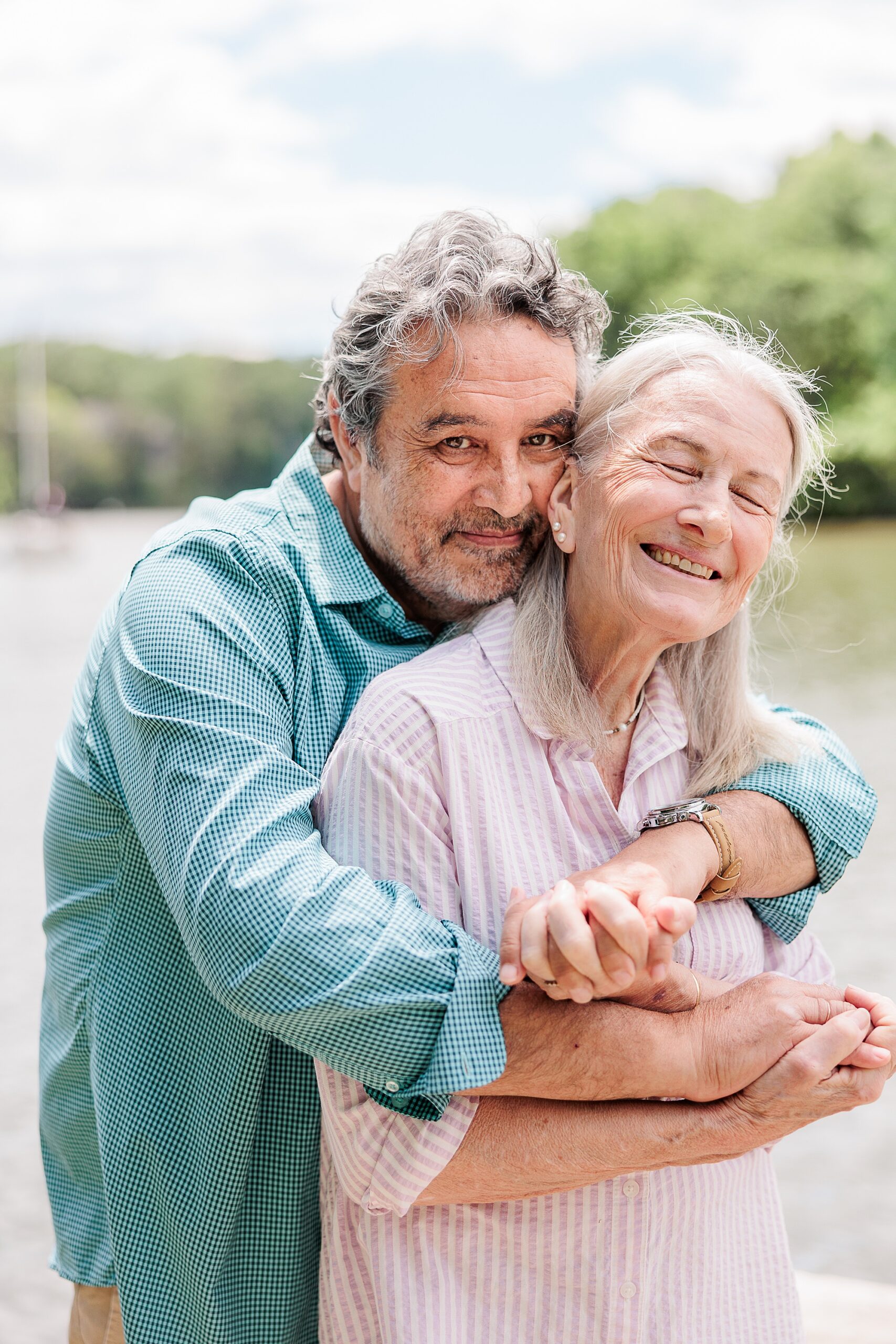 grandparents hug on dock during family photos in Maryland