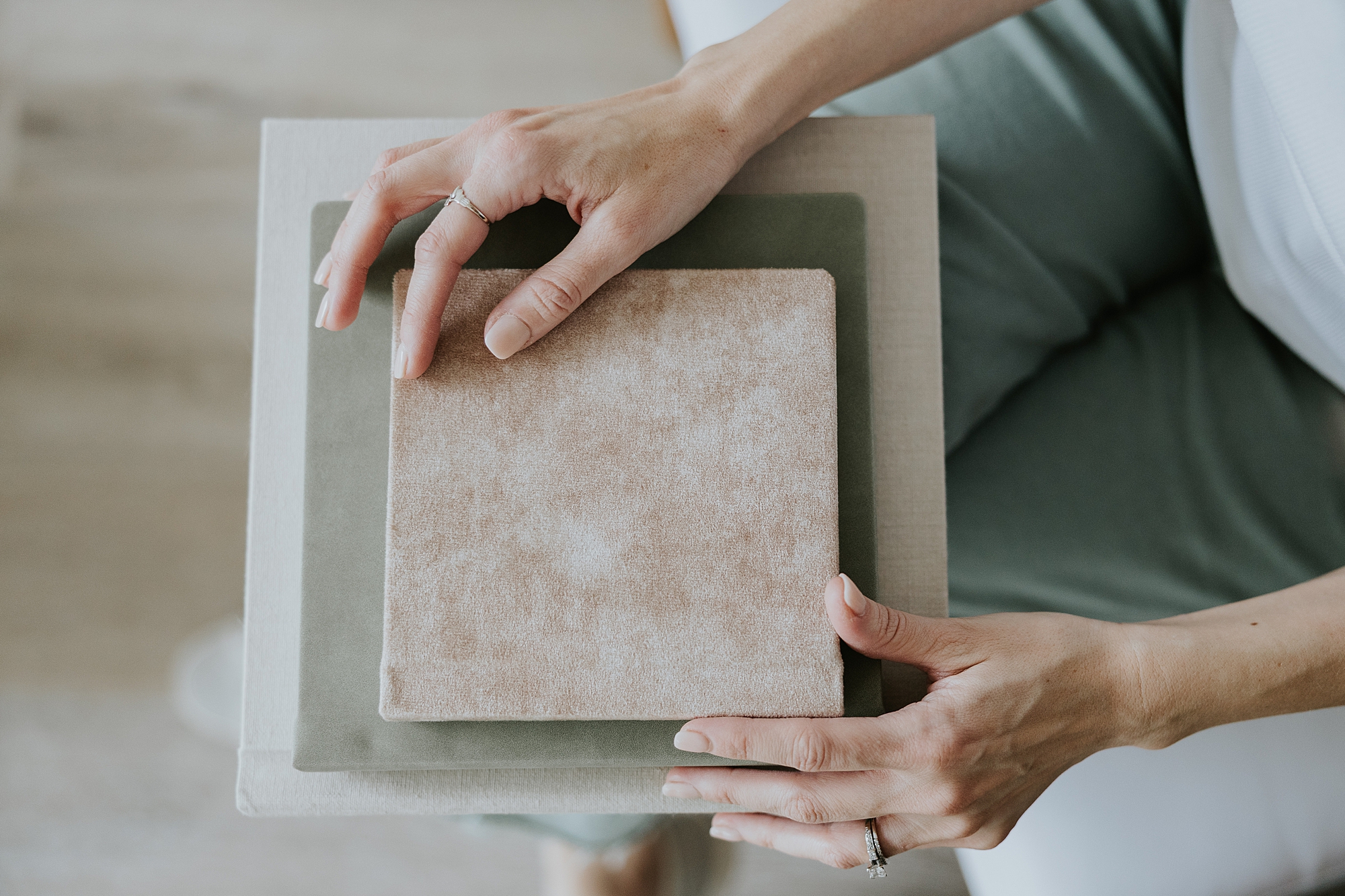 DC Maryland family photographer holds pile of photo albums on her lap