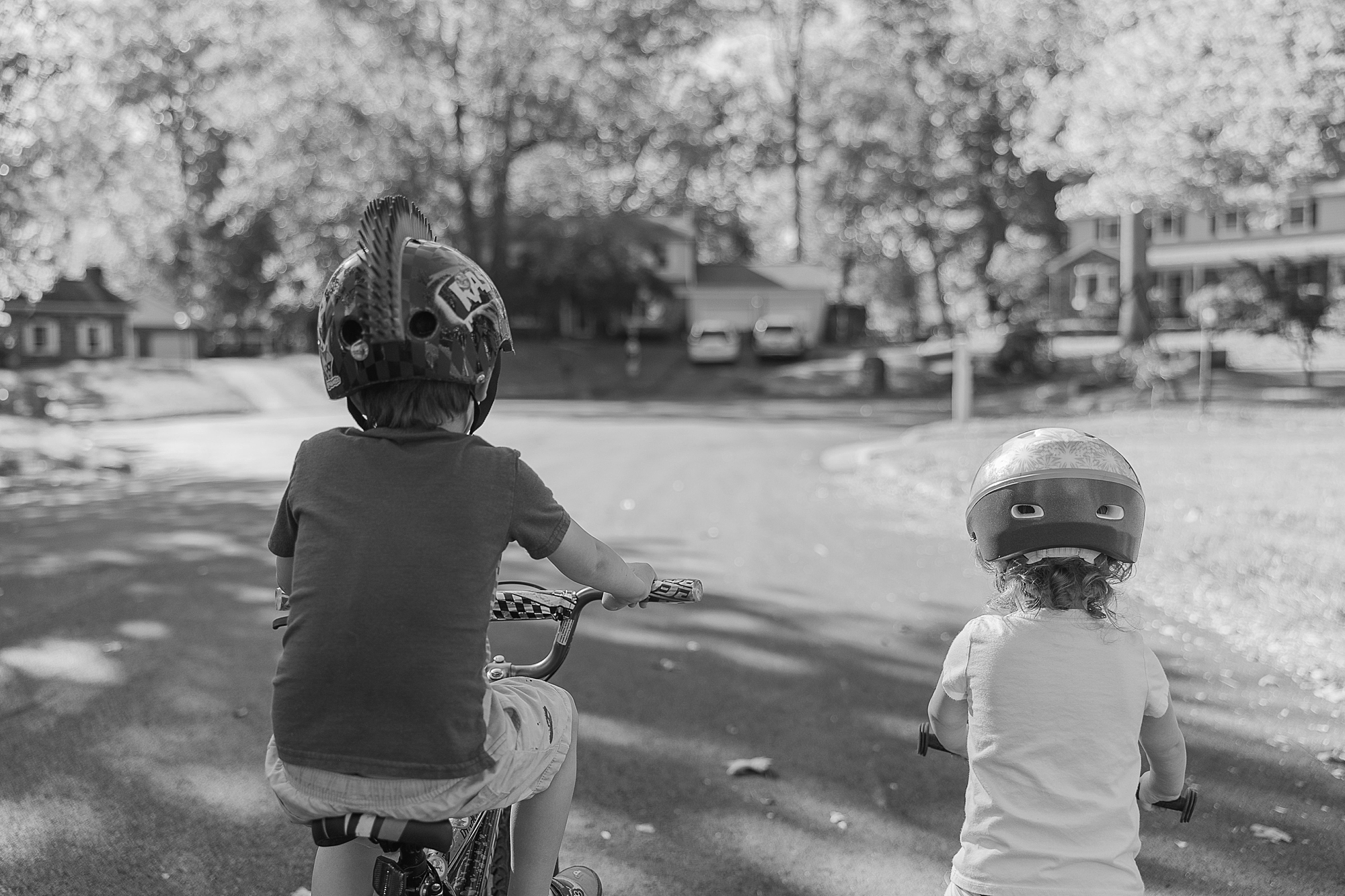 children ride bikes on driveway during Maryland documentary family photos